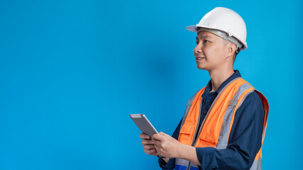 Confident young engineer wearing orange and a safety helmet stands holding a laptop, phone with various emotions.