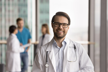 Enthusiastic professional. Head shot portrait young male doctor practitioner intern modern...