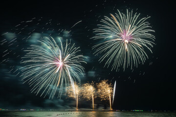 Multicolored Fireworks Exploding Over Water
