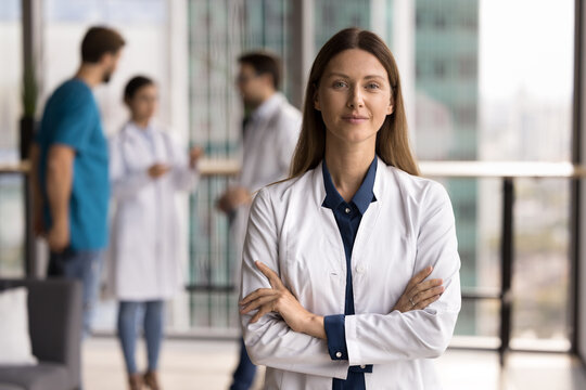 Reliable medical insurance. Confident friendly young lady in lab coat doctor consultant healthcare manager meet patient in clinic look at camera offer professional service at modern center. Copy space