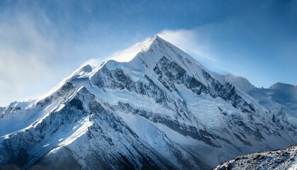 Obraz premium A breathtaking snow-covered mountain peak under a clear blue sky.