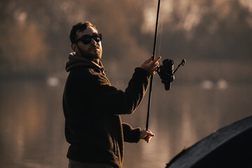 Carp fishing on a lake, fisherman angling scene