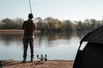 Carp fishing on a lake, fisherman angling scene