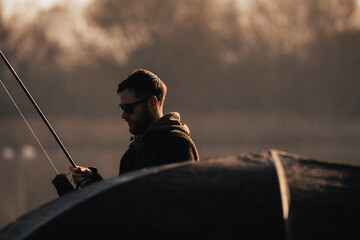 Fishing scene, carp fisherman on a lake angling with rods