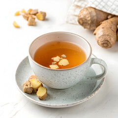 Ginger tea in a cup with ginger on white background