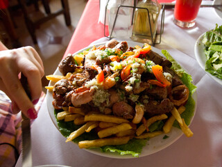 On a dining table, there lies a delicious plate filled with crispy french fries and savory meat, ready to be enjoyed and savored