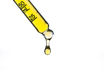 Yellow liquid in dropper on white background	