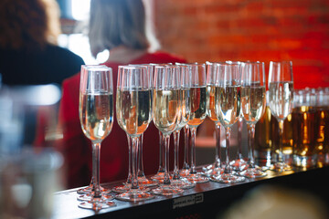 A carefully arranged row of elegant champagne glasses are beautifully lined up on a sleek bar, ready for celebrations and festivities