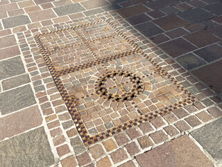 Intricate cobblestone mosaic design on stone pavement with geometric patterns