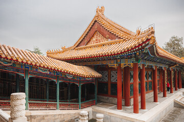 There is a beautiful Chinese building located with a serene pond situated in front of it, enhancing its picturesque appeal and charm