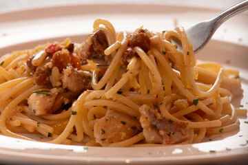Eating spaghetti with pine nuts, raisin and mushroom