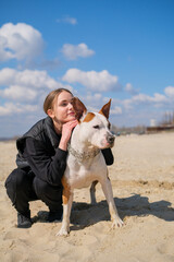 Portrait of cute teenage girl hugging her dog, American Staffordshire Terrier