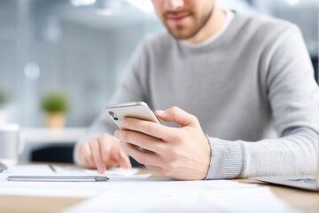 Man using smartphone at work desk. mobile communication and modern work environment