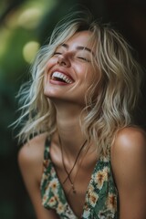 Naklejka premium Blonde woman laughing joyfully in nature wearing floral dress
