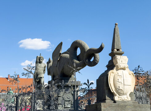 Historic stone scultures and iron fence under blue sky in Klagenfurt