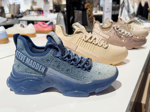 Stylish steve madden sneakers display: blue and beige fashion footwear on store shelf
