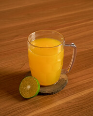 A Warm Citrus Beverage Served in a Glass with a Slice of Fresh Orange for a Comforting and Refreshing Presentation.