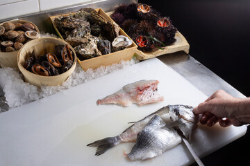 filleting fish in a restaurant kitchen