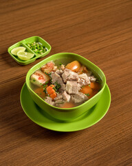 A Bowl of Indonesian Beef Soup with Lime on the Side, Savory and Hearty Beef Soup Served Hot, Infused with Spices.