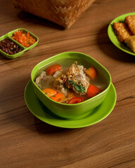 A Hearty Bowl of Indonesian Beef Soup with Spicy Sambal and Fried Tempeh on the Side, Traditional Comfort Food with Rich Broth and Balanced Flavors.