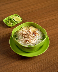 A Bowl Of Free-Range Chicken Soup With Clear Broth And Lime On The Side, Offering A Fresh, And Nourishing Traditional Taste Of Indonesian Cuisine.