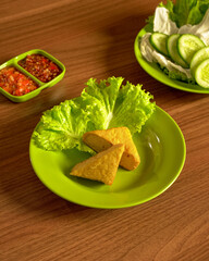 Fried Tofu Served With Fresh Raw Vegetables And Spicy Sambal On The Side, A Simple Flavorful Indonesian.