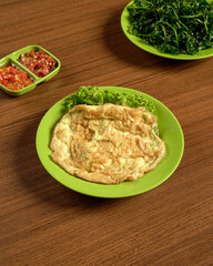 Indonesian Omelette Served With Fresh Vegetables And Spicy Sambal On The Side, A Traditional Meal Of Flavor And Local Culinary Character.