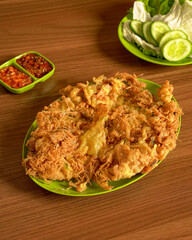 Crispy Curly Fried Egg Served With Fresh Vegetables And Spicy Sambal On The Side For A Delightful Traditional Indonesian Meal.