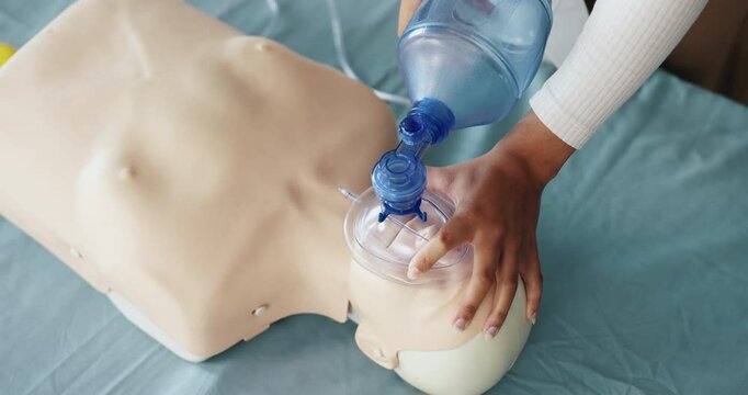 Mask, cpr and hands of person with dummy for demonstration, tutorial and lesson for first aid. Healthcare, above and woman with respiratory ventilator for paramedic course, learning or medical class