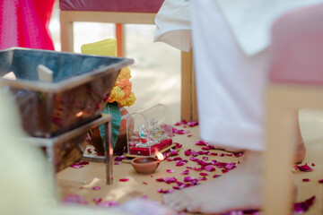 Ceremonial Setup: Pooja altar with flowers, lamp, and deity figurines amidst scattered rose petals,...