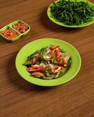 Stir-Fried Jengkol with Fresh Raw Vegetables and Spicy Sambal on the Side, A Bold and Flavorful Traditional Indonesian Dish.