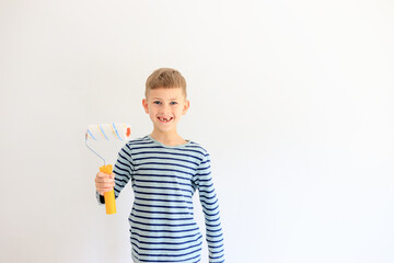 A young boy renovating a room, sanding the walls with sandpaper and painting them white with a...