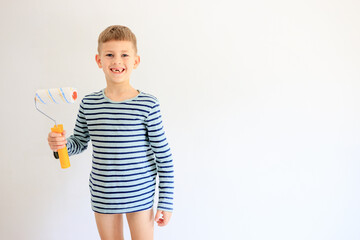 A young boy renovating a room, sanding the walls with sandpaper and painting them white with a roller. Home improvement and DIY repair concept