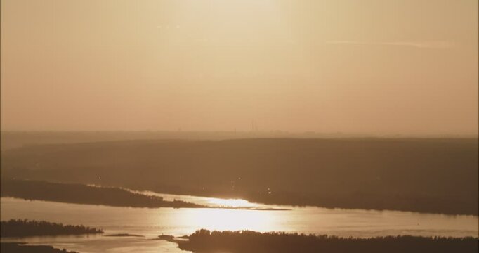 Golden sunset over river with motorboat leaving wake