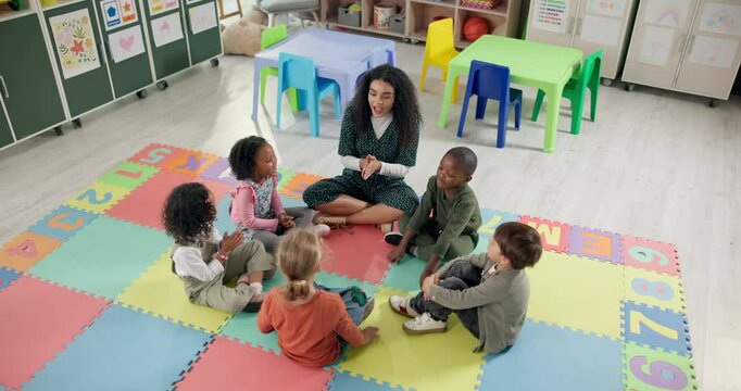 Woman, teacher and learning with kids above in nursery for activity, education or listening skills at kindergarten. Female person, educator or instructor with children in sing along, class or school
