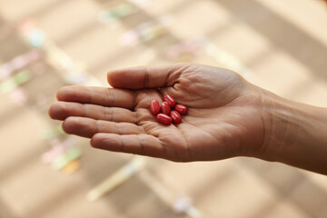 Woman's hand holding red pills