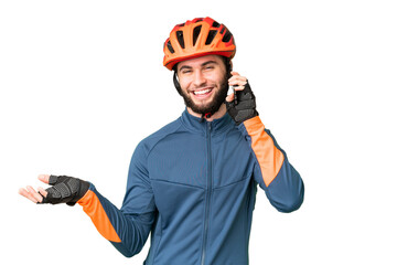 Young cyclist man over isolated chroma key background keeping a conversation with the mobile phone with someone