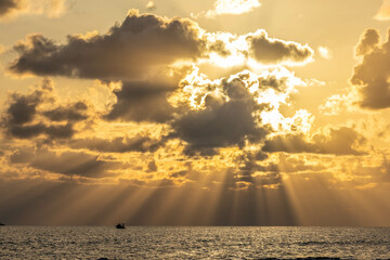 Golden sunset over the sea with dramatic clouds and sun rays breaking through. Serene and cinematic view. Side, Turkey, Mediterranean