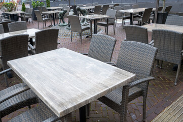 Empty tables and chairs occupying outdoor cafe terrace