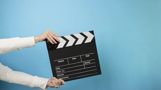 Film industry scene, action moment, director using a clapboard to begin a motion picture