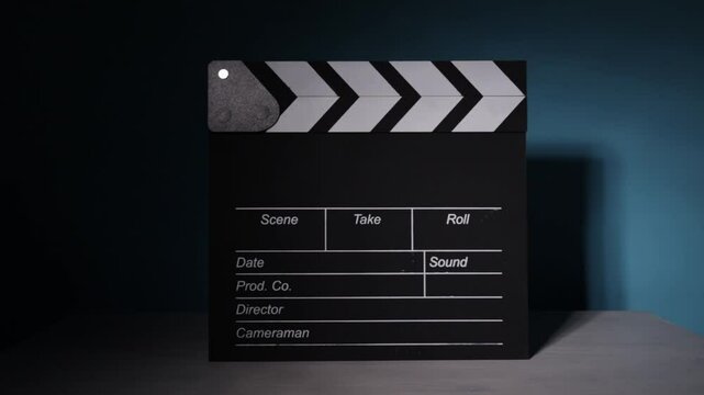 movie clapperboard, spotlight movement, filmmaking process, film set ambiance, director's tool, entertainment industry, professional recording, video production