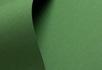 Matte designer paper texture with smooth, curved folds and waves. Elegant, clean surface in soft green, leafy green, and forest green tones. Stylish, natural earthy monochrome backdrop, perfect for a.