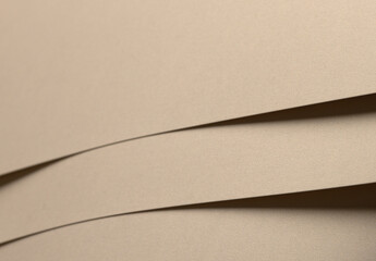 Paper background with matte texture. Curved wave shape in golden, beige, and light brown tones, smooth soft surface, warm pastel highlight, elegant composition, refined organic form..