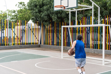Fototapeta premium Man Preparing to Shoot Basketball on Outdoor Court