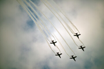 image of aerobatic stunts,Show of force jets,Colorful contrails of aerobatic team,aerial acrobatic team releasing colored smoke in the sky during shows,colorful bombardment by jet fighter