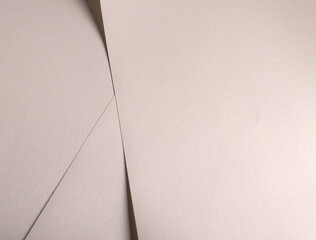Paper background with satin pearlescent texture. Matte folded layers, smooth surface in pale gold...