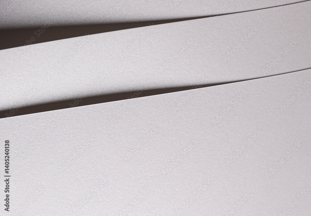 Fototapete White pearl paper background with a glossy satin texture and diagonally folded, overlapping layers. Icy silver and pale grey tones create a soft, elegant, and luxurious composition with crisp contours