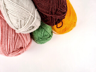 Colorful skeins of yarn laid out on a white background. The texture of the soft fibers is clearly visible, creating and warm mood. handicrafts, knitting, textile design and creativity.