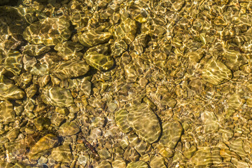 Tranquil Riverbed Serenity: Sunlit Rocks and Clear Waters