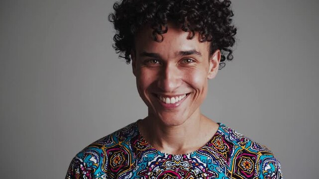 Non-binary person smiling into camera, inclusive portrait of joy